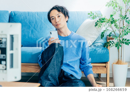 自宅でテレビを見る若い男性 108266659