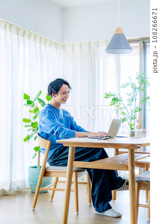 ダイニングでパソコンを使う男性 108266671