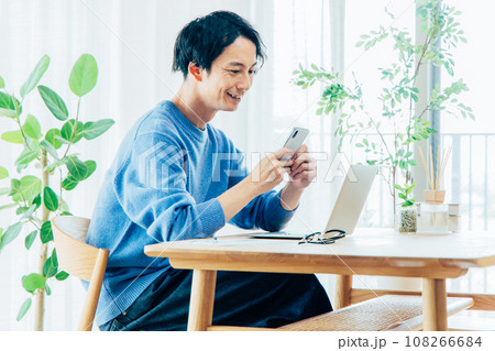 ダイニングでパソコンを使う男性 108266684