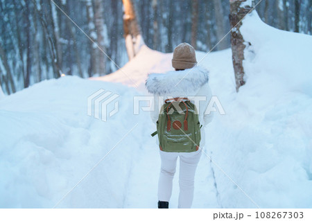 Woman tourist Visiting in Furano, Traveler in Sweater sightseeing Ningle Terrace Cottages with Snow in winter. landmark and popular for attractions in Hokkaido, Japan. Travel and Vacation concept Woman tourist Visiting in Furano, Traveler in Sweater sightseeing Ningle Terrace Cottages with Snow in winter. landmark and popular for attractions in Hokkaido, Japan. Travel and Vacation concept 108267303