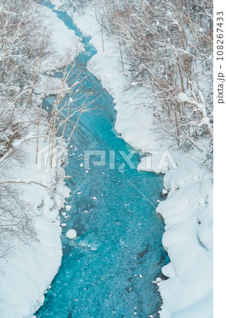 Shirahige Waterfall with Snow in winter, Biei river flow into Blue Pond. landmark and popular for attractions in Hokkaido, Japan. Travel and Vacation concept 108267433