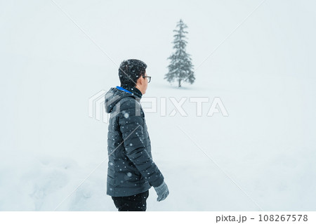 man tourist Visiting in Biei, Traveler in Sweater sightseeing Christmas tree with Snow in winter season. landmark and popular for attractions in Hokkaido, Japan. Travel and Vacation concept 108267578