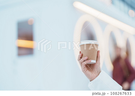 woman tourist holding hot Coffee or Tea paper cup with snow in winter season during travel in Niseko. landmark and popular for attractions in Hokkaido, Japan. Travel and Vacation concepts 108267633