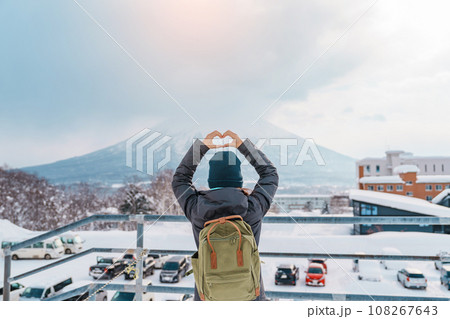 Woman tourist Visiting in Niseko, Traveler in Sweater sightseeing Yotei Mountain with Snow in winter season. landmark and popular for attractions in Hokkaido, Japan. Travel and Vacation concept 108267643