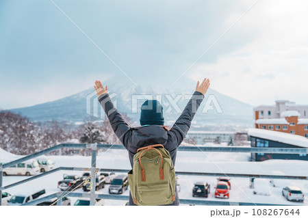 Woman tourist Visiting in Niseko, Traveler in Sweater sightseeing Yotei Mountain with Snow in winter season. landmark and popular for attractions in Hokkaido, Japan. Travel and Vacation concept 108267644