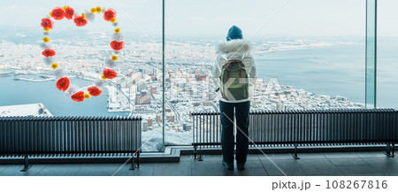 Woman tourist Visiting in Hakodate, Traveler in Sweater sightseeing view from Hakodate mountain with Snow in winter. landmark and popular for attractions in Hokkaido, Japan.Travel and Vacation concept 108267816