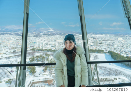 Woman tourist Visiting in Hakodate, Traveler in Sweater sightseeing view from Goryokaku Tower with Snow in winter. landmark and popular for attractions in Hokkaido, Japan.Travel and Vacation concept 108267819