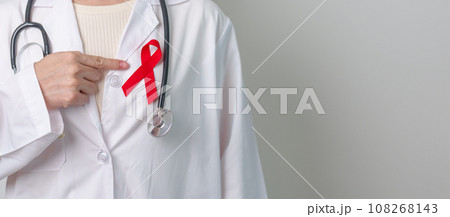 Doctor with Red Ribbon for December World Aids Day, acquired immune deficiency syndrome, multiple myeloma Cancer Awareness month and National Red ribbon week. Healthcare and world cancer day concept 108268143