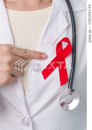 Doctor with Red Ribbon for December World Aids Day, acquired immune deficiency syndrome, multiple myeloma Cancer Awareness month and National Red ribbon week. Healthcare and world cancer day concept 108268144