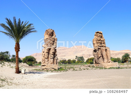 Famous Colossi of Memnon, Valley of Kings, Luxor, Egypt. Ancient stone statue of Pharaoh Amenhotep III in Theban Necropolis Famous Colossi of Memnon, Valley of Kings, Luxor, Egypt. Ancient stone statue of Pharaoh Amenhotep III in Theban Necropolis 108268497