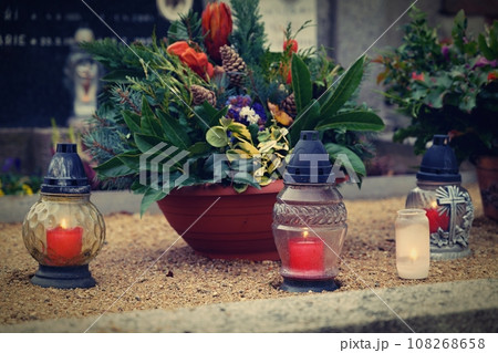 All Souls' Day. A lit candle on the grave. Background with cemetery. Autumn time and holidays. Soulstice - remembrance of the dead - Halloween holiday. 108268658