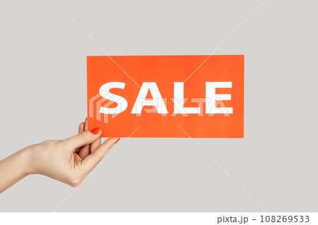 Closeup of woman hand showing card with sale inscription, special offer, shopping discounts. Indoor studio shot isolated on gray background. Closeup of woman hand showing card with sale inscription, special offer, shopping discounts. Indoor studio shot isolated on gray background. 108269533