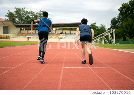 Two Asia male teenagers starting running in track for practice in Stadium 108270010