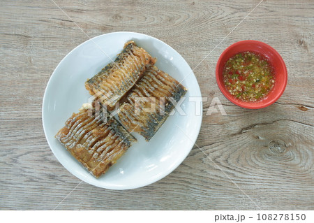 crispy fried chop large head hair tail fish arranging on plate dipping spicy chili sauce in cup    108278150