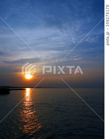 太陽の光を反射する海に沈む夕日 108278178
