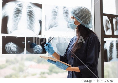 Indian doctor in mask and cap using tablet for check x-ray Indian doctor in mask and cap using tablet for check x-ray 108278961
