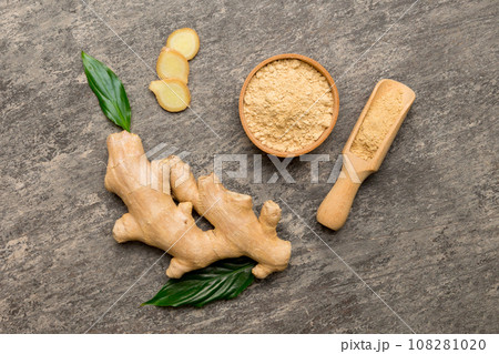 Finely dry Ginger powder in bowl with green leaves isolated on colored background. top view flat lay 108281020