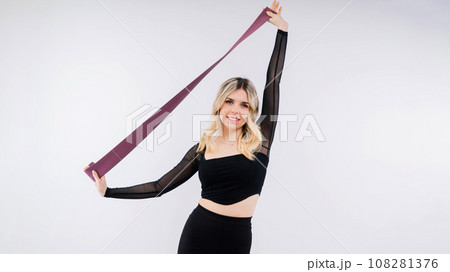Young woman workout with resistance band on white background. Strength and motivation. Young woman workout with resistance band on white background. Strength and motivation. 108281376
