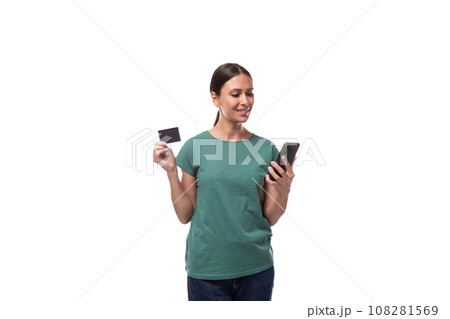 young brunette woman in t-shirt holding credit card and smartphone 108281569