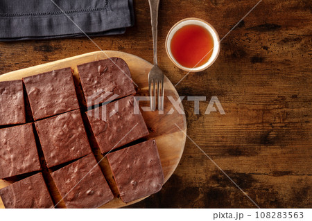 Chocolate brownie with tea, coffee cake, overhead flat lay view Chocolate brownie with tea, coffee cake, overhead flat lay view 108283563