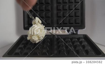 Process of making soft waffles with waffle iron. Pouring liquid dough in iron wafer placed on wooden table. Close up slow motion video clip. High quality 4k footage Process of making soft waffles with waffle iron. Pouring liquid dough in iron wafer placed on wooden table. Close up slow motion video clip. High quality 4k footage 108284382