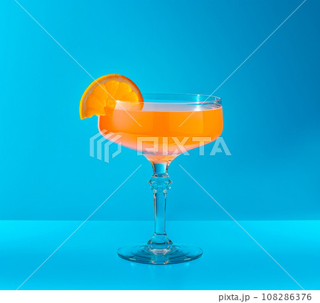 Tequila Sunrise cocktail garnished with orange slice, in the style of bold color field 108286376
