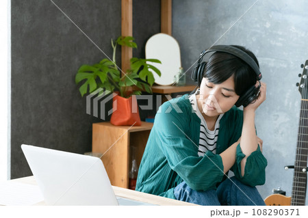 ヘッドフォンで音楽を聴く女性 108290371