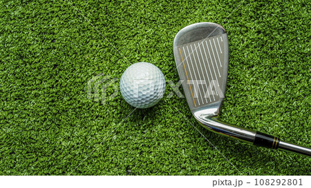 Golf club and golf ball close up in grass field with sunset. Golf club and golf ball close up in grass field with sunset. 108292801