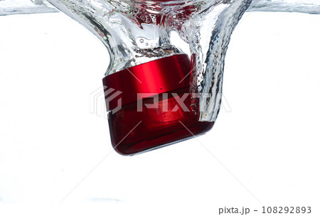 Red Cosmetic container fall into clear water with air bubble. Cosmetic treatment container drop to clear water of freshness. White background isolated freeze element Red Cosmetic container fall into clear water with air bubble. Cosmetic treatment container drop to clear water of freshness. White background isolated freeze element 108292893