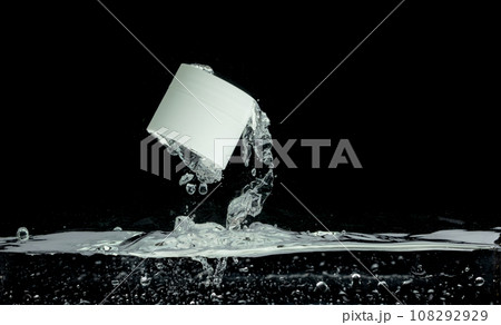 Cosmetic container fall into clear water with air bubble. Small cosmetic treatment container drop to clear water of freshness. Black background isolated freeze element 108292929