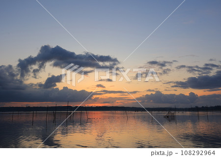 朝焼けの色に染まる湖面 108292964