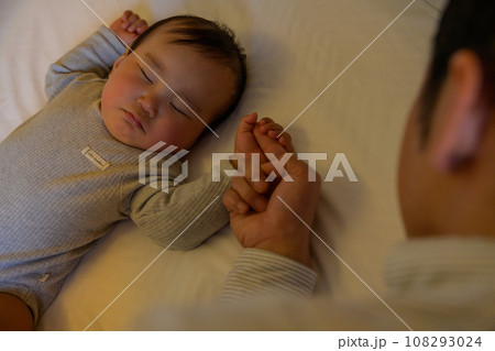 赤ちゃんをベッドに寝かせる父親 指を握る子ども イクメン 寝かしつけ 添い寝 把握反射 0歳乳幼児 赤ちゃんをベッドに寝かせる父親 指を握る子ども イクメン 寝かしつけ 添い寝 把握反射 0歳乳幼児 108293024