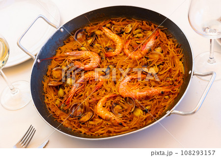 Seafood fideua with mussels, scallops and prawns in paella pan with aioli 108293157