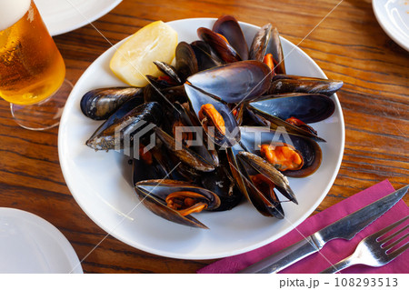Baked mussels in shells with slice of lemon and beer Baked mussels in shells with slice of lemon and beer 108293513