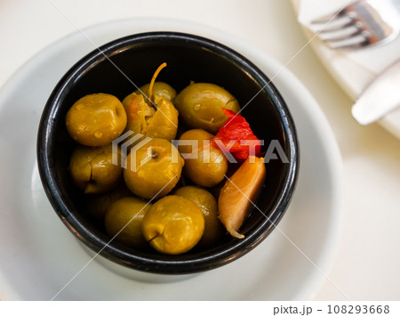Green pitted olives served with garlic on platter 108293668
