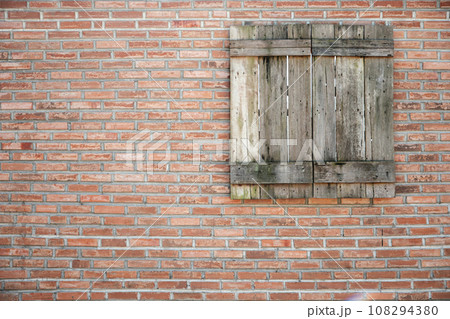 old wooden window on brown brick wall background old wooden window on brown brick wall background 108294380