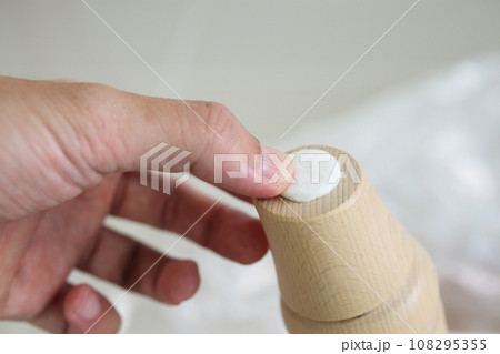 Man sticking floor care pad at sofa leg 108295355