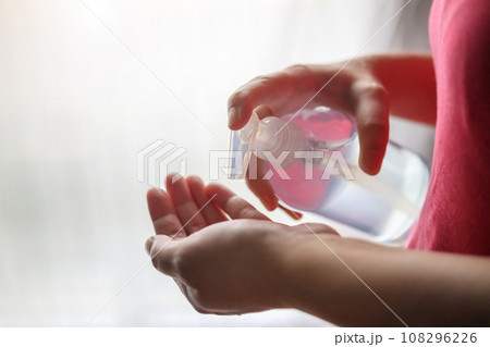 Woman using alcohol sanitizer gel rub for cleaning hand COVID-19 corona virus prevention concept 108296226
