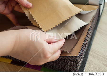 female designer with fabric color samples choosing textile for curtains 108296381