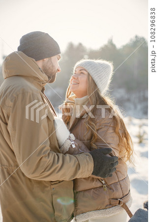 Portrait of romantic couple having fun on winter walk. Man and woman hugging. Family wearing warm jacket and knitted hats. Portrait of romantic couple having fun on winter walk. Man and woman hugging. Family wearing warm jacket and knitted hats. 108296838