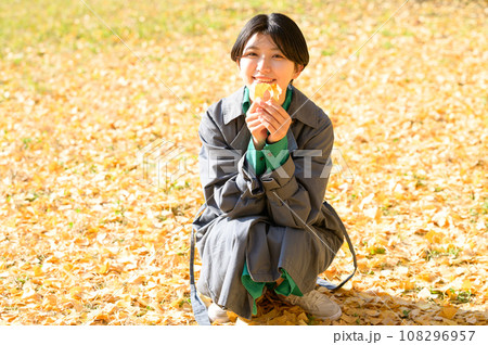 秋の落葉を楽しむ女性 108296957