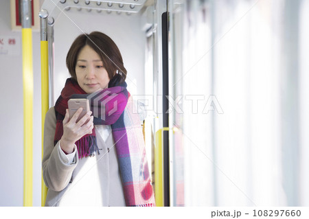 電車でスマホを見る冬服を着たミドル女性 電車でスマホを見る冬服を着たミドル女性 108297660