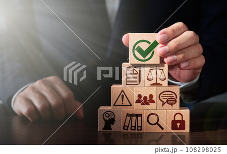 コンプライアンスと経営マネジメントのイメージ。法令を遵守する。テーブルに木のブロックを積み上げる男性 108298025