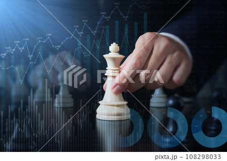 投資戦略と挑戦のイメージ。チェスの駒を前に進めるビジネスマン。多数の金融データと統計のグラフ。 108298033