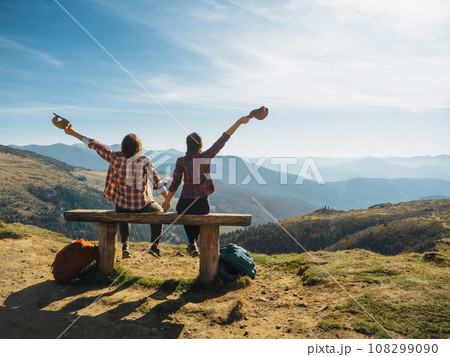 Couple of Hikers With Raised Hands in Front of Landscape Valley View on Top of a Mountain Couple of Hikers With Raised Hands in Front of Landscape Valley View on Top of a Mountain 108299090