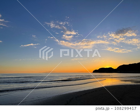 鎌倉の海の風景、夕焼け空と伊豆半島遠景、浜辺の夕焼け、波打ち際の風景、海に沈む夕日と波間のサーファー 108299417
