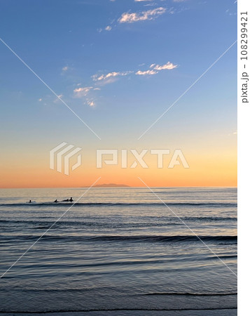 鎌倉の海の風景、夕焼け空と大島遠景、浜辺の夕焼け、波打ち際の風景 