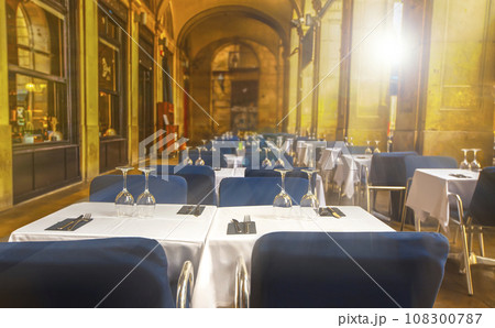 Empty summer street cafe with covered white tables on sunlight 108300787