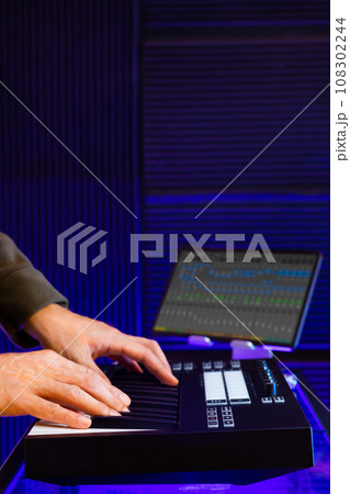 male musician, composer, producer hands playing midi keyboard in studio 108302244