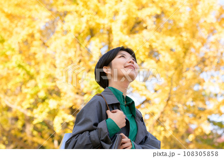 紅葉の公園を一人楽しむ女性 108305858